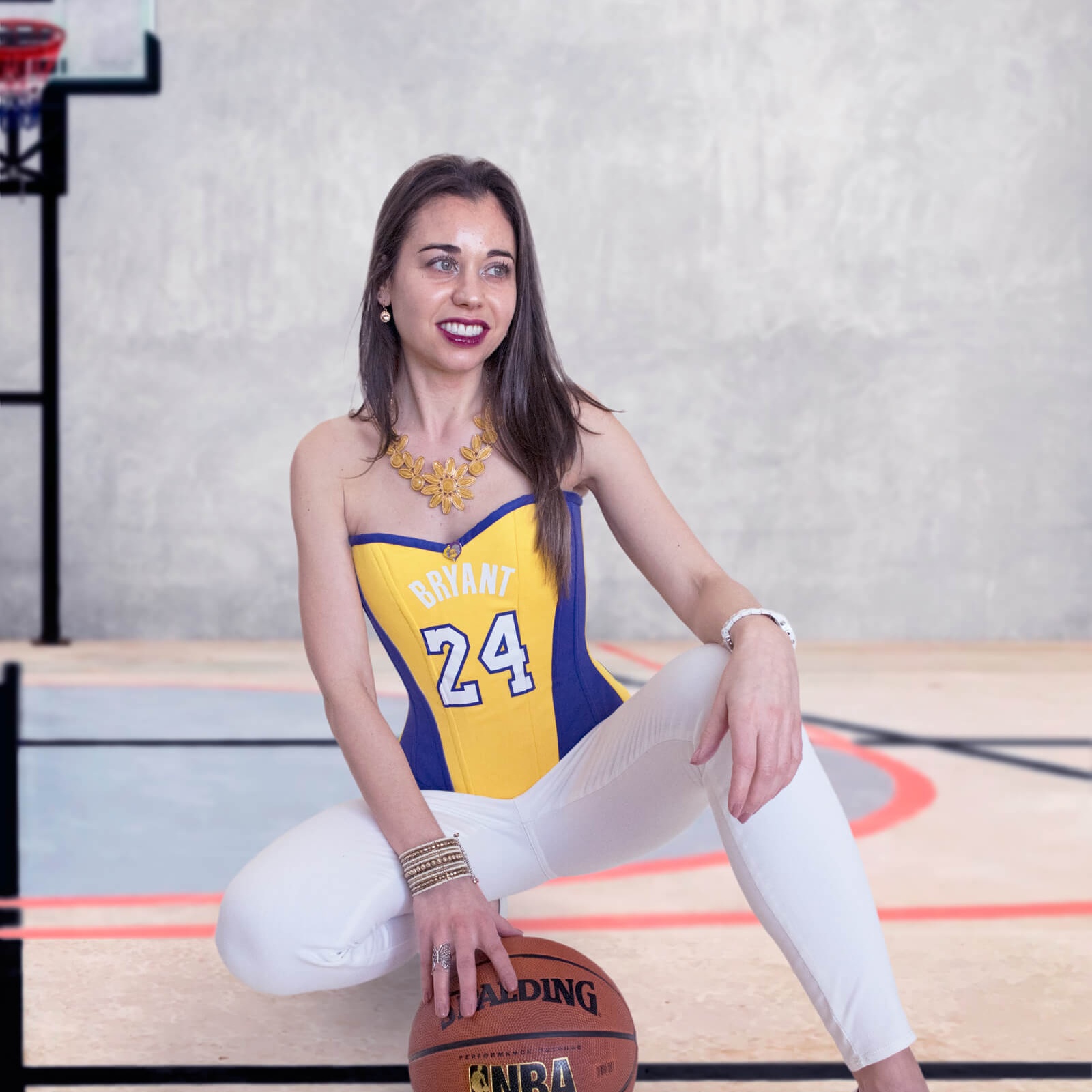 Stella holding basketball wearing Los Angeles Lakers Kobe Bryant Corset #24 in an indoor basketball court